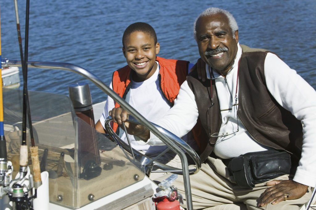 Grandfather Taking Grandson Fishing in Boat