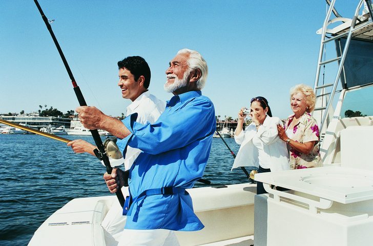 Two Men Fishing at the Stern of a Boat as a Woman Photographs Them